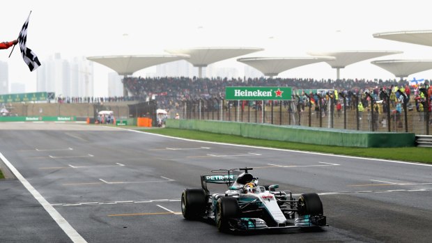 Chequered love: Mercedes driver Lewis Hamilton of Great Britain crosses the finish line at Shanghai International Circuit.