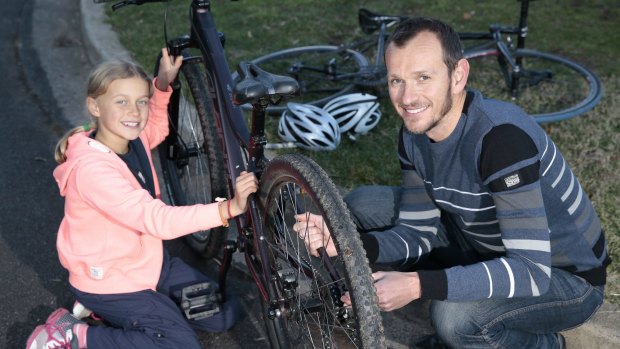 Isobel Jones, 9, of Downer gets ready to go for a bike ride with her father Stuart Jones. 