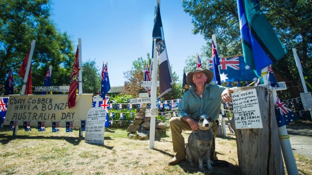 Dave 'Spurs' Goodall, pictured with his dog RM, decorated his front yard with flags for an Australia Day party celebration.