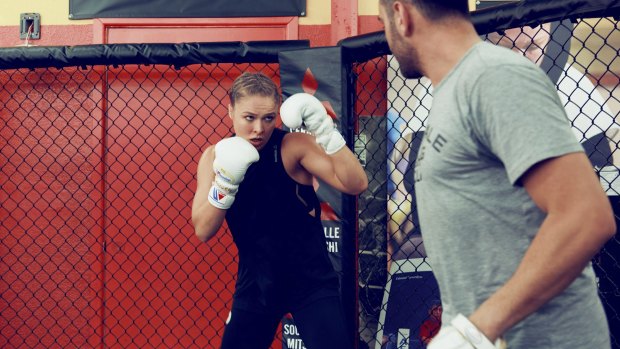 "I punched him in the face with a straight right, then a left hook," she writes. "He staggered back and fell against the door": Rousey in her autobiography.