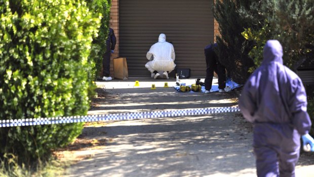 Forensic investigators process evidence in the driveway of the Wanniassa home where Neal Wilkinson was allegedly murdered.