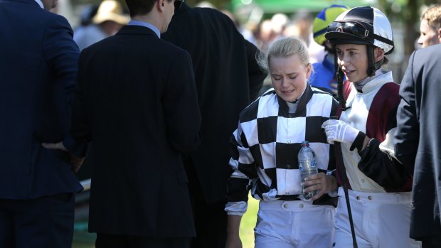 Winona Costin, left, speaks with fellow jockey Kathy O'Hara after being thrown off Layo Layo in the mounting yard before race three.