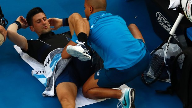Running repairs: Novak Djokovic receives treatment for an apparent hip complaint.