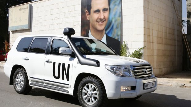 A poster of Syrian President Bashar al-Assad adorns a wall as the vehicle of United Nations special envoy for Syria Staffan de Mistura leaves his hotel on Sunday. 