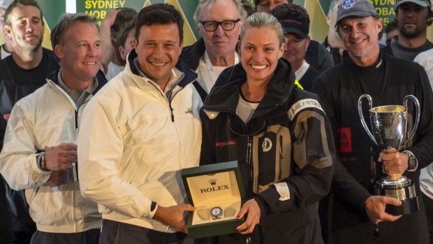 Patrick Boutellier, managing director of Rolex Australia, presents Comanche co-owner Kristy Hinze-Clark with the prize for taking line honours in the Sydney-Hobart race. Jim Clark is between them at rear.