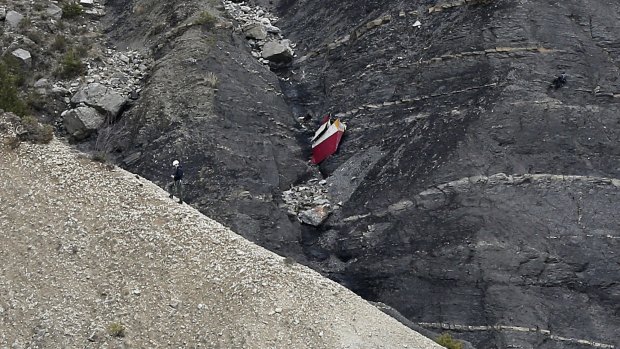 A rescue worker climbs past debris at the crash site.