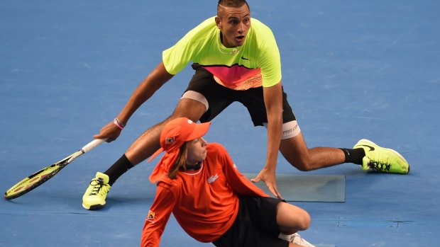 Australia's Nick Kyrgios (top) plays a shot around a ballboy during his men's singles match against Italy's Andreas Seppi on day seven of the January 2015 Australian Open tennis tournament in Melbourne. 
