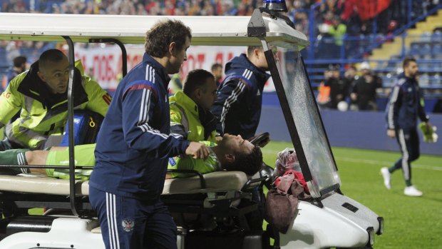 A medical vehicle transports Russia's goalkeeper Igor Akinfeev, hit with a flare in the head, off of the pitch.