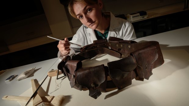 Sophie Lewincamp (conservator) working on ammunition belt from Australian Lighthorse leather bandalier.