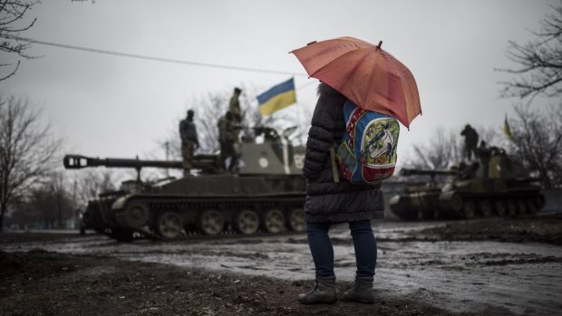 A schoolgirl looks at Ukrainian armoured vehicles on the outskirts of Donetsk.