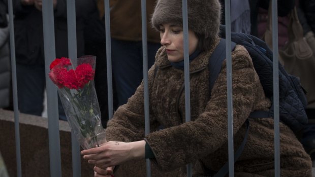 A woman lays flowers at the place where Boris Nemtsov was killed.