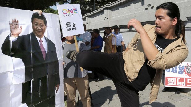 A protester kicks a portrait of Chinese President Xi Jinping outside the office of Taiwanese President Ma Ying-jeou on Thursday.