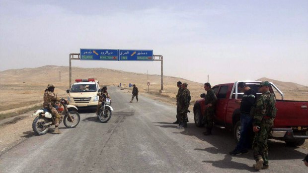 Syrian government soldiers gather at the entrance of Palmyra on Thursday. 