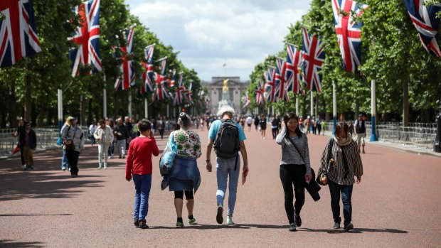 Tourists gather on The Mall in view of Buckingham Palace the day after the London Bridge terror attack.
