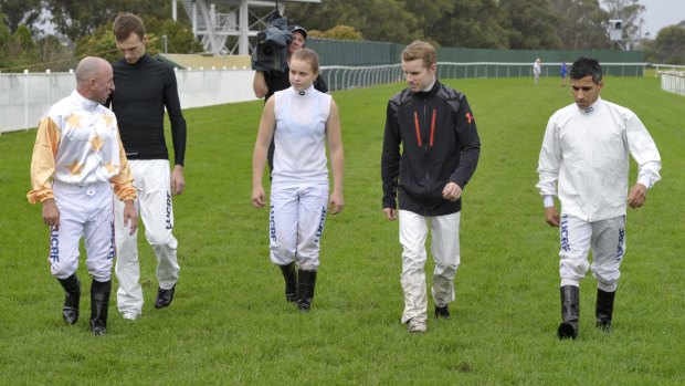 Surface tension: Jim Cassidy (left) leads jockeys on an inspection of the Hawkesbury track on Saturday.