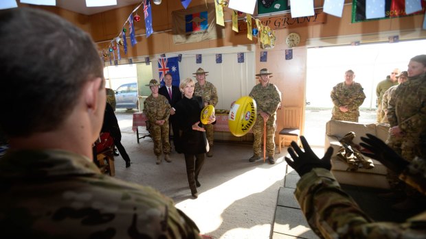 Julie Bishop plays football with Australian troops during her visit on Australia Day. 