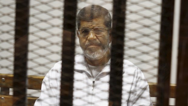 In this May 2014 file photo, Egypt's ousted President Mohamed Morsi sits in a defendant cage in the Police Academy courthouse in Cairo, Egypt.