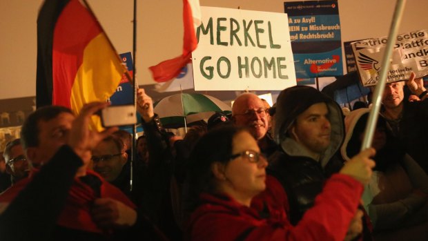 Supporters of the AfD political party protest against German Chancellor Angela Merkel's liberal policy towards migrants and refugees. 