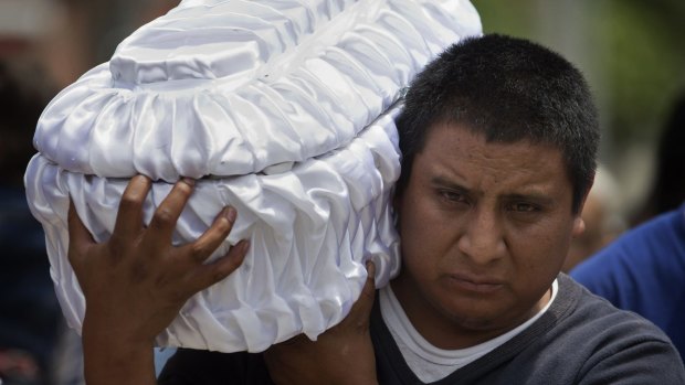 Welsar Nazario carries the coffin of his five-month-old nephew, landslide victim Alezandro Macario, to the Santa Catarina Pinula cemetery on the outskirts of Guatemala City on Saturday.