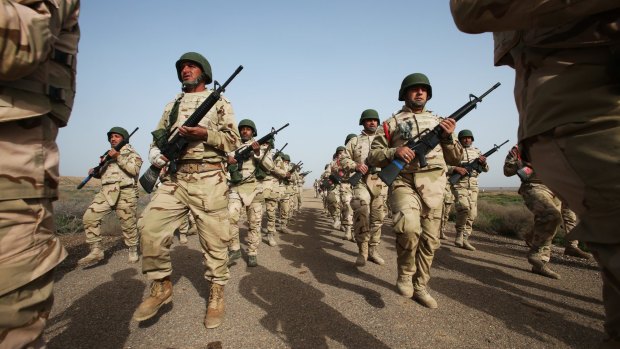 Soldiers form the Iraq Security Forces Ninewa Operations Command-NOC-Commando Battalion march and sing at the rifle range. 