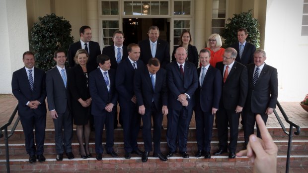 A photographer adjusts the placement of the new ministerial appointments in a photograph with Prime Minister Tony Abbott and Governor-General Sir Peter Cosgrove at Government House in Canberra on Tuesday.