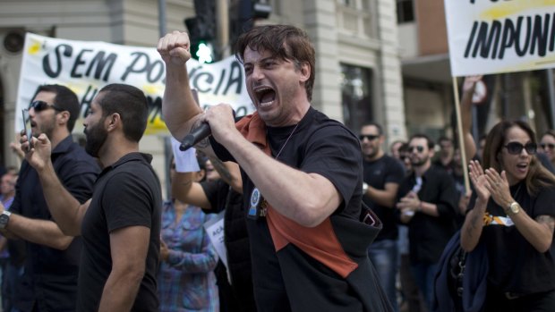 A Rio police officer yells into a microphone during a protest demanding better labour conditions.