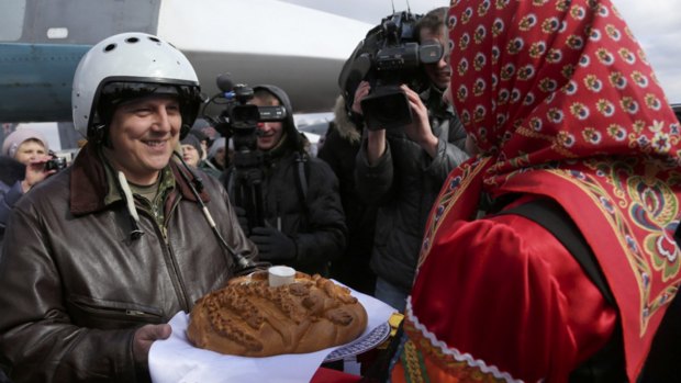 A Russian pilot who returned from Syria is welcomed with traditional bread and salt at an airbase near the Russian city Voronezh on Tuesday.