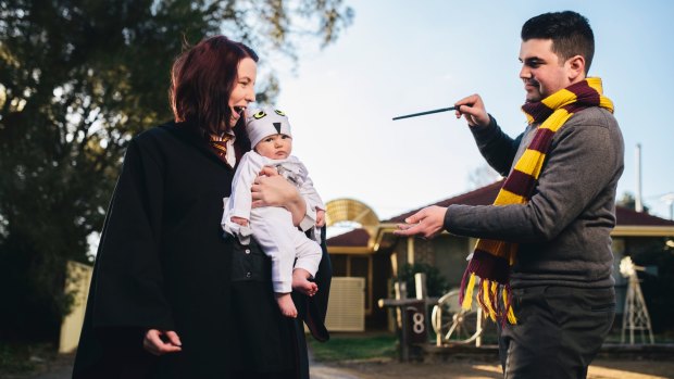 Cosplay couple Bec and Andrew Grayson as Gryffindor students, with baby daughter Aurora as Hedwig.
