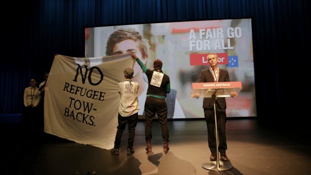 Protesters disrupt the debate on Labor's asylum seeker policies.