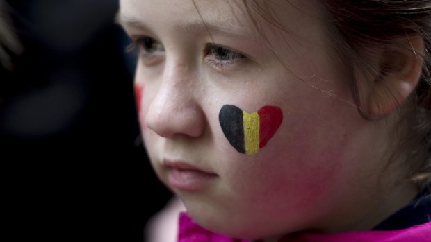 A child looks on during a vigil for the victims of the Brussels attacks at the Belgium Consulate in Montreal, Canada, on Wednesday.