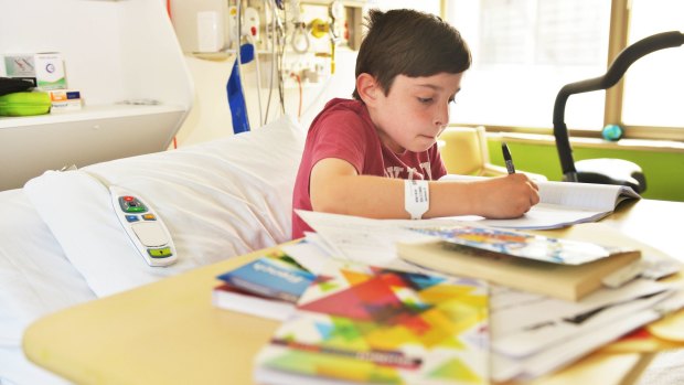 Jackson Seccombe does homework while receiving treatment at Monash Children's Hospital. 