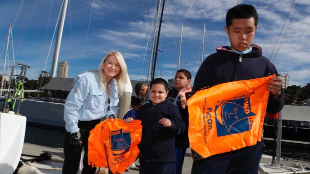 Members of the group Sailors with DisABILITIES Khan and Hao Nguyen from Wairoa School receive presents from Ann Flynn in Sydney.