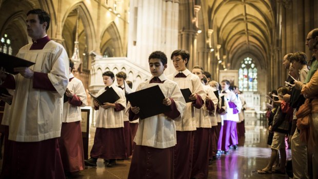 Choristers sing in file at St Mary's Cathedral, Sydney for the Christmas Day Mass.
