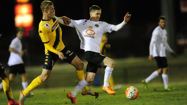 Josh Bingham of Central Coast Mariners and Shane Murray of Gungahlin United in action.