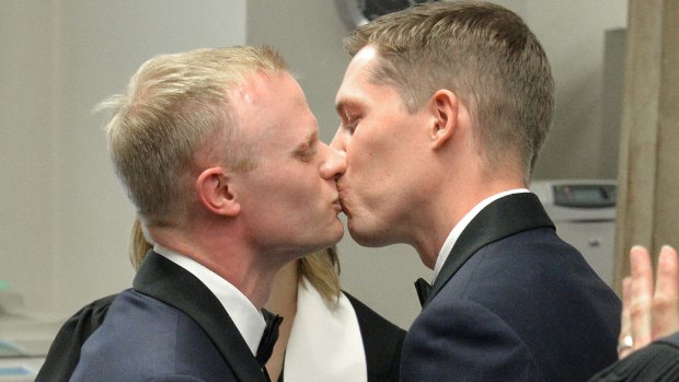 Benjamin Moore and Tadd Roberts kiss after their marriage ceremony in Louisville, Kentucky.