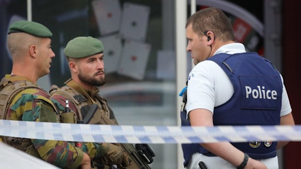 A police officer speaks to members of the armed forces in the Molenbeek suburb of Brussels.