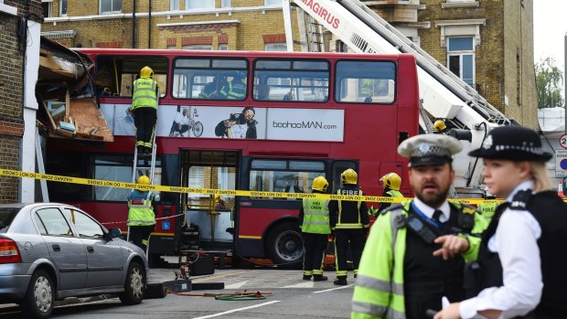 Emergency services personnel check a crashed double-decker bus in Lavender Hill.