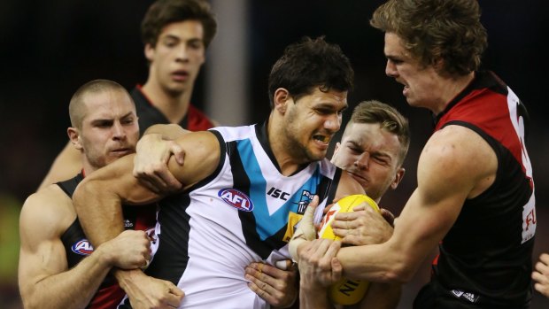 Swamped: Port Adelaide's Patrick Ryder tackled by three Bombers.