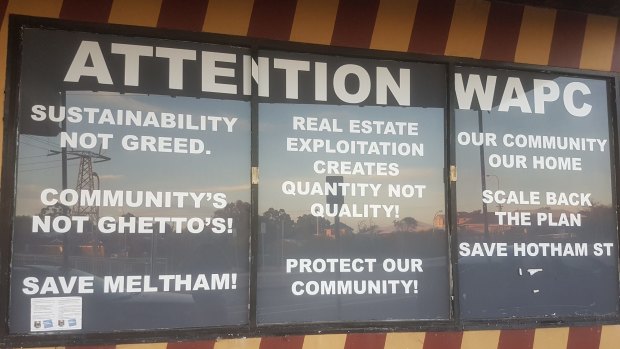 Protest signs at a Meltham shopfront suggest an erosion of community trust on planning issues. 