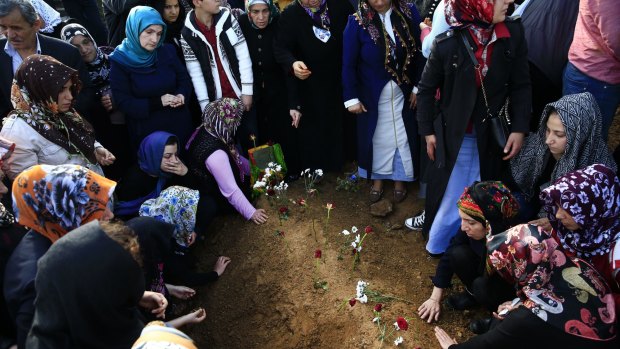 People mourn at the grave of a victim of the bombing.