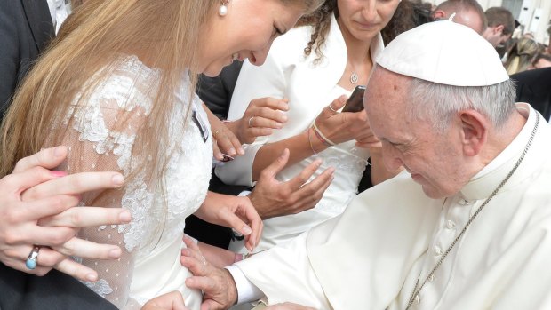 Pope Francis blesses a pregnant woman during his weekly general audience.