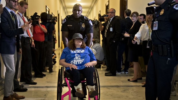 A demonstrator in a wheelchair protests cuts to Medicaid.