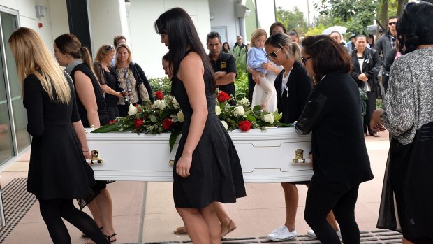 Friends and family carry Tara Brown's coffin into her funeral service.