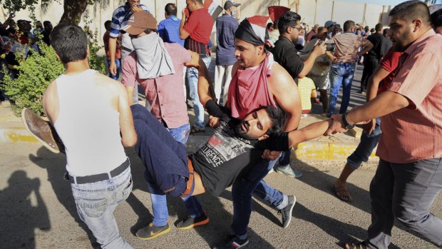 An injured protester is carried away.