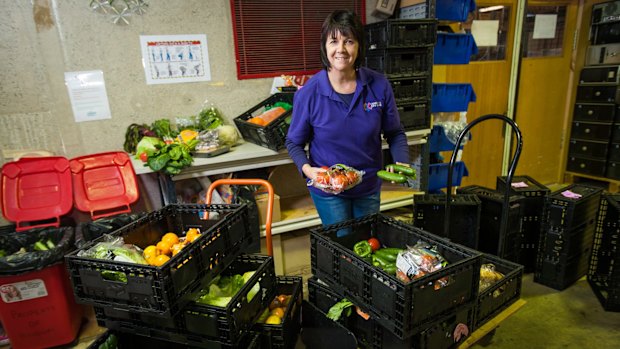 HandUp manager Sandra MacDonald sorts produce to go on to shelves.
 