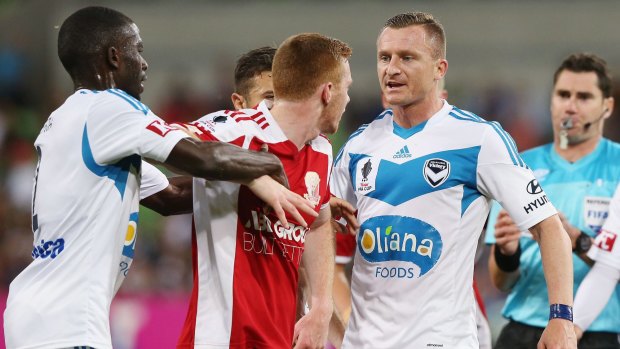 Jason Geria of the Victory tries to play peacemaker as Nick Hegarty of Hume City and Besart Berisha of the Victory get into a verbal stoush.