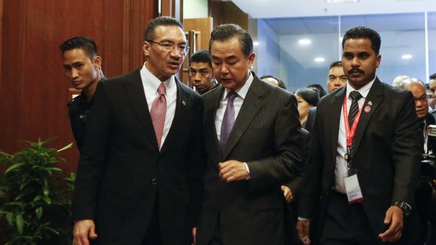Chinese Foreign Minister Wang Yi, centre, speaks to Malaysian Defence Minister Hishammuddin Hussein in Kuala Lumpur on Tuesday. 