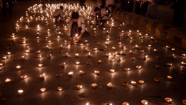 Pakistani students light lamps for the victims of an attack by Taliban gunmen.