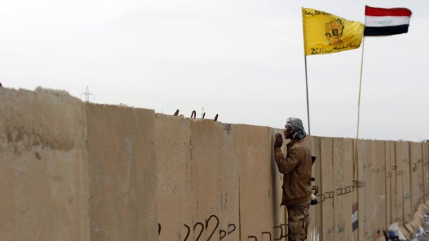 A Shiite militia fighter keeps watch on the southern edge of Tikrit.