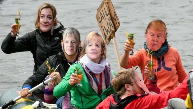 Participants of the protest against the G20 summit demonstrate on an inflatable boat wearing masks with the likeness of from left: High Representative of the European Union for Foreign Affairs, Federica Mogherini, British Prime Minister Theresa May, German Chancellor Angela Merkel and US President Donald Trump.
